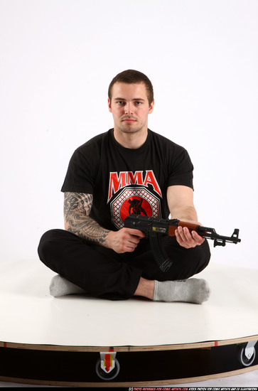 Man Adult Athletic White Fighting with submachine gun Sitting poses Sportswear