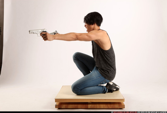 Man Young Athletic Fighting with gun Kneeling poses Casual Asian