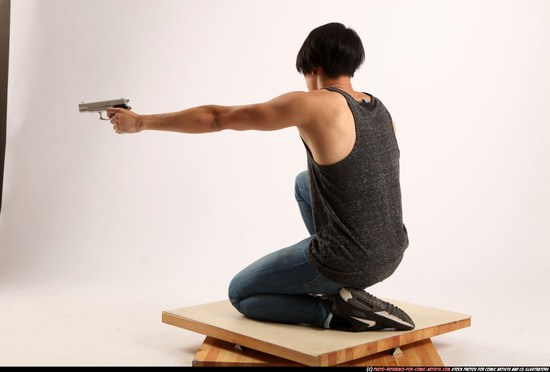 Man Young Athletic Fighting with gun Kneeling poses Casual Asian