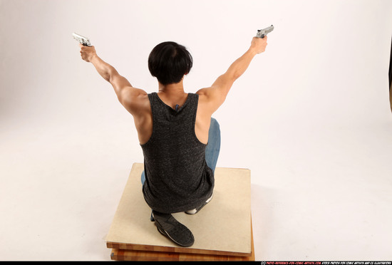 Man Young Athletic Fighting with gun Kneeling poses Casual Asian