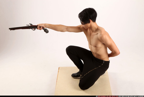 Man Young Athletic Fighting with gun Kneeling poses Pants Asian