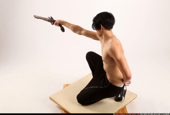 Man Young Athletic Fighting with gun Kneeling poses Pants Asian