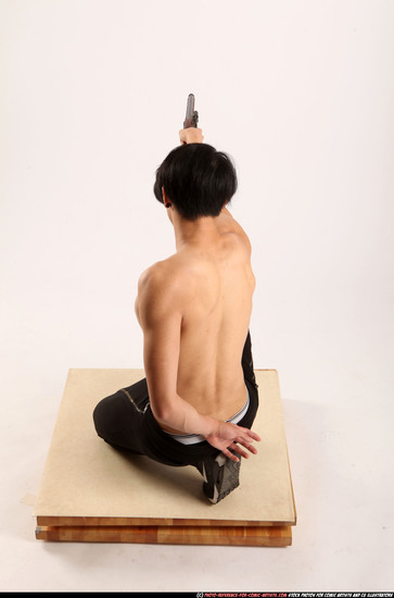 Man Young Athletic Fighting with gun Kneeling poses Pants Asian