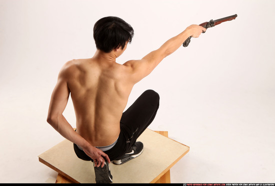 Man Young Athletic Fighting with gun Kneeling poses Pants Asian