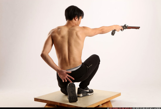 Man Young Athletic Fighting with gun Kneeling poses Pants Asian