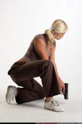 Woman Adult Athletic White Fighting with gun Kneeling poses Sportswear