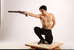 Man Young Athletic Fighting with gun Kneeling poses Pants Asian