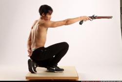 Man Young Athletic Fighting with gun Kneeling poses Pants Asian