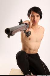 Man Young Athletic Fighting with gun Kneeling poses Pants Asian