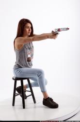 molly-sitting-aiming-pistol